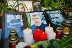 Květiny, svíčky a fotografie na místě, kde našla policie oběšeného Vitalije Šyšova.