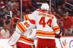 Brankář Daniel Vladař přijímá gratulace od spoluhráče z Calgary Erika Gudbransona