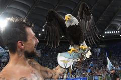 Fotbalista Francesco Acerbi s živým maskotem klubu Lazio Řím, orlem Olympia.