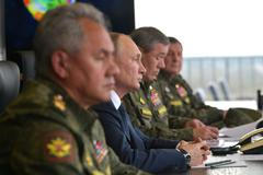 Vedle Vladimira Putina sedí vpravo náčelník generálního štábu ruské armády Valerij Gerasimov a vlevo ministr obrany Sergej Šojgu.