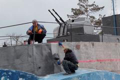 Rusové narychlo “leští” zdevastovaný Mariupol. V parku zničeného města natírají loď