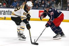 David Pastrňák z Bostonu (88) a hráč Columbusu Patrik Laine (29) v utkání NHL.