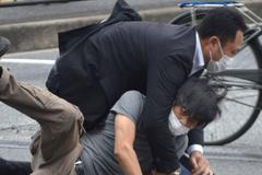 Střelec na japonského expremiéra (v šedém tričku).