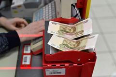 Storublové bankovky na kase v obchodě v sibiřském Omsku.