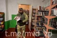 Ozbrojení Rusové se točili v okupovaném Melitopolu, jak odstraňují v knihovně „závadné“ knihy