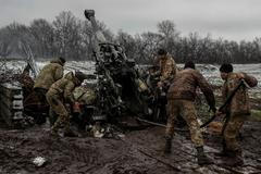 Mužstvo pálí z houfnice M777. Rozbahněný terén je typický pro listopad a prosinec na Donbase.