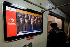 Novoroční projev Vladimira Putina s ruskými vojáky, vysílaný ve vagonu moskevského metra.