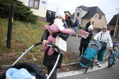 Ženy a děti z Ukrajiny si odnášejí potravinové balíčky a dárky, které pro ně v neděli 19. prosince 2023 připravili štědří a ochotní lidé v Ostravě - Staré Bělé za pomoci mnoha dárců.