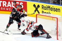 Rakouský brankář David Madlener zasahuje proti Connoru Bedardovi