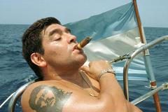 FILE PHOTO: Argentine soccer star Diego Maradona smokes a Cohiba as he rides a sailboat