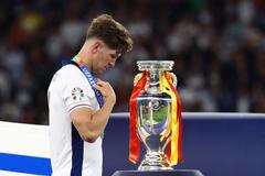 John Stones smutně prochází vedle trofeje pro vítěze po finále Eura 2024 Španělsko - Anglie