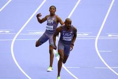 Americký atlet Quincy Wilson předává Vernonu Norwoodovi v závodě štafet na 4x400 m na OH 2024 v Paříži