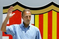 FILE PHOTO: Former Dutch international Neeskens waves in front of Barcelona's badge after his arrival at the Nou Camp stadium