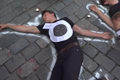 Před budovu KSČM namalovali účastníci pochodu obrysy obětí 1969