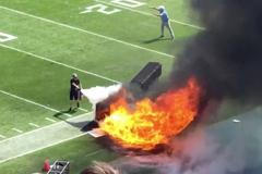 People try and extinguish fire from burning equipment used during pregame, du