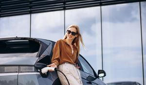 Žena nabíjí elektromobil, ilustrační foto