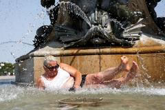 A woman lies in the water of the Fontaine des Trois Graces, in Bordeaux