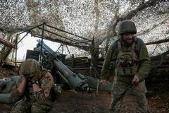 FILE PHOTO: Ukrainian servicemen fire a self-propelled howitzer towards Russian troops near the frontline town of Pokrovsk