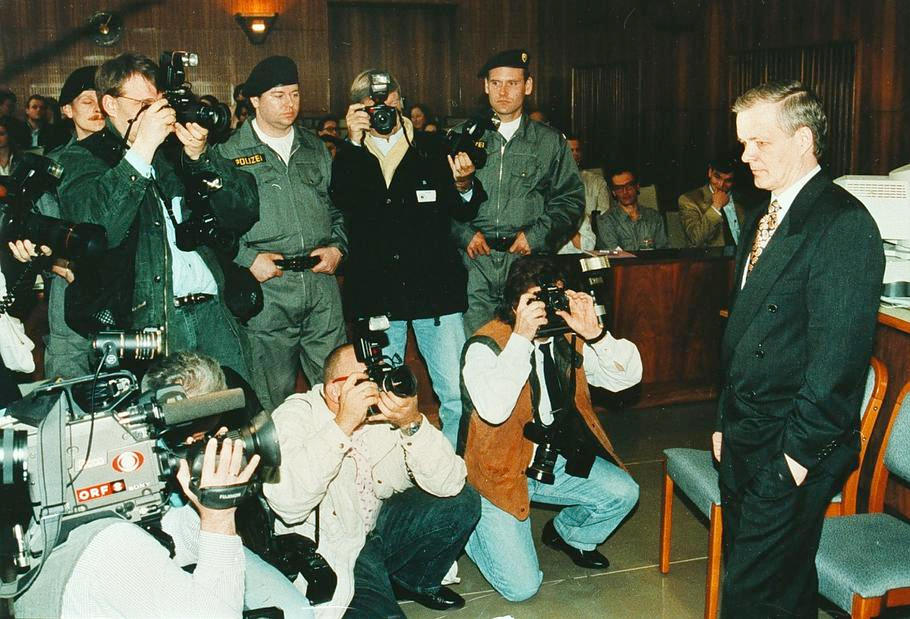 Jack Unterweger obklopený fotografy v soudní síni v Grazu během procesu, kde čelil obžalobě z jedenácti vražd, Rakousko, červen 1994.