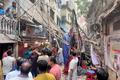 Residents stand in an alley after vacating their house next to a fallen scaffolding following an earthquake in Dhaka