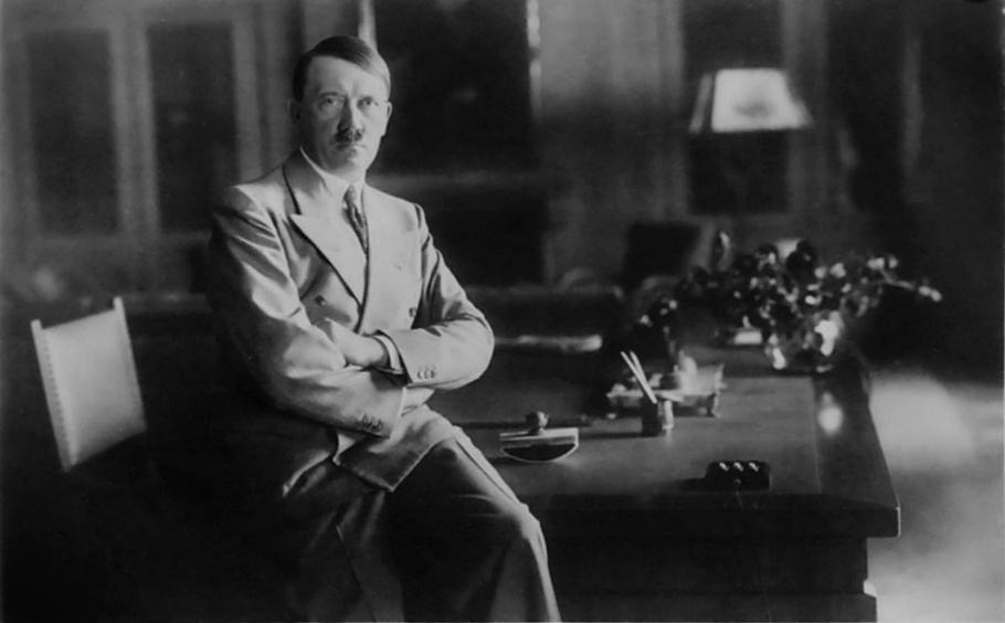 Adolf Hitler sedí ve 30. letech ve své pracovně za stolem – muž, kolem něhož se dnes točí DNA studie o Kallmannově syndromu i posměšná píseň o „jednom varleti“.