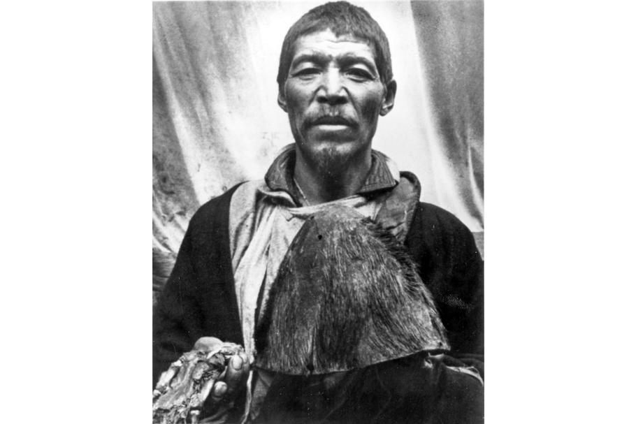 Lamaistický mnich předvádí údajný skalp a ruku yettiho z kláštera Pangboche.