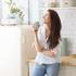 Young happy woman drinking coffee on the kitchen in the morning