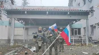 Ruští vojáci drží ruské vlajky před nemocnicí v Kupjansku v Charkovské oblasti na Ukrajině. Snímek pochází z videa zveřejněného 21. listopadu 2025.