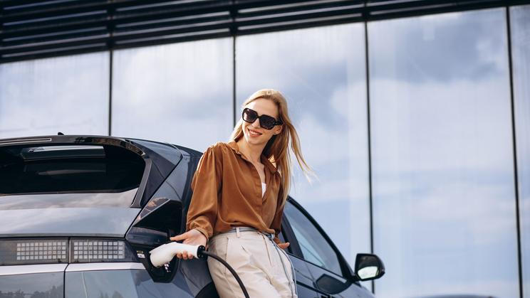 Žena nabíjí elektromobil, ilustrační foto