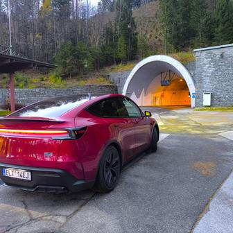 Tesla Y na tradičním místě před tunelem, v jehož středu probíhá rakousko-slovinská státní hranice. Průsmyk Loibl, odkud pochází snímek, leží v nadmořské výšce 1367 metrů.