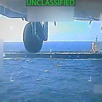 U.S. military helicopter flies near an oil tanker during its seizure by the United States off the coast of Venezuela