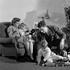 1930s 1940s FAMILY AROUND CHRISTMAS TREE BOY PLAYING WITH TRAIN DAD HELPING MOM AND GIRL IN CHAIR