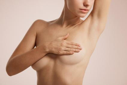 ["Closeup cropped portrait young woman with breast pain touching chest colored isolated on background"]