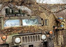 Ukrainian serviceman camouflages a HMMWV vehicle near the frontline city of Kupiansk