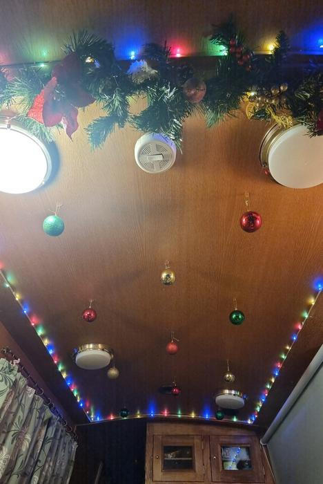 Klasický vánoční stromek se na loď nevejde, ale i s tím si poradili. „Zdobíme strop a kamarádka nám vyrobila mašle na míru pro naše maličké dveře. Je to neuvěřitelně útulné místo na svátky.“