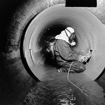 Pracovník v německém Offenbachu provádí průrazy pro domovní přípojky v plastovém kanalizačním potrubí. Datum: 3. srpna 1998.