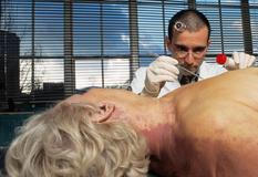 Forenzní entomologové zkoumají hmyz na mrtvých tělech k určení příčiny a přibližného času smrti. Na snímku je forenzní entomolog Mark Benecke při pitvě na Klinice univerzity v Düsseldorfu, Německo, 2003.