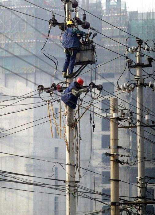 Práce pod vysokým napětím zahrnuje montáž a opravy elektrických zařízení ve výškách nebo blízko částí rozvodu pod napětím. Riziko úrazu elektrickým proudem je vysoké a práce vyžaduje přísné dodržování bezpečnostních předpisů. Pracovníci na fotografii opravují elektrické vedení na sloupu v Pekingu, 21. prosince 2004.