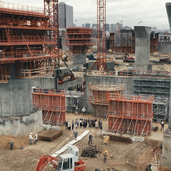 Když se děj filmu Architekt přesune na staveniště, kamera se zaměřuje na chaotickou masu dělníků, jeřábů, bláta a improvizace. 