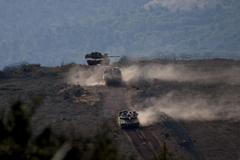 FILE PHOTO: Israeli military vehicles manoeuvre along the Israel-Lebanon border as seen from northern Israel