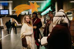 Lidé spěchají po eskalátoru nahoru i dolů, oči sklopené, tváře unavené.