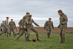 Propagandistická inscenovaná fotografie britských a německých vojáků při fotbalovém zápase během vánočního příměří 1914.