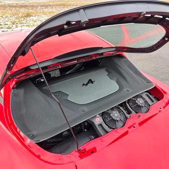 Uprostřed umístěný přeplňovaný benzinový čtyřválec se schovává za předními sedadly. Má průhledný kryt, dostat se k němu ale lze až po odjištění šroubů v kufru auta.