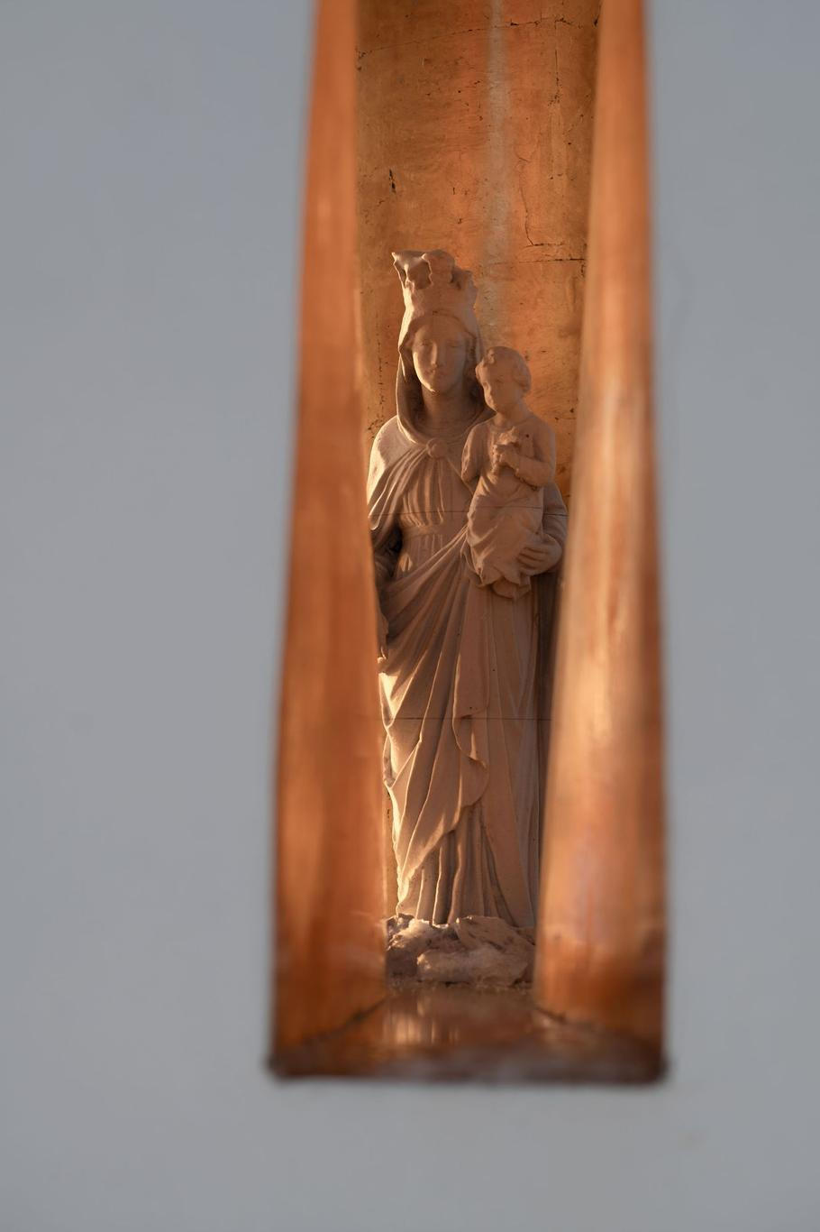 Uvnitř je soška Panny Marie - schoulená, chráněná, neviditelná na první pohled - a kolemjdoucí si k ní musí dojít.