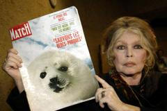 FILE PHOTO: Former French actress Brigitte Bardot displays a 1969 copy of french magazine "Paris Match" showing ..