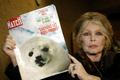 FILE PHOTO: Former French actress Brigitte Bardot displays a 1969 copy of french magazine "Paris Match" showing ..