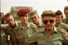 Vojáci poslouchají plukovníka Jána Vala (ve slunečních brýlích), velitele Československého samostatného protichemického praporu.