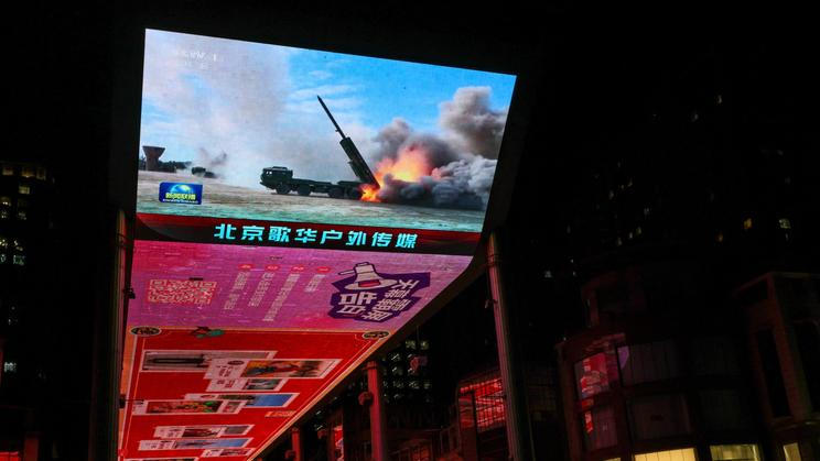 Screen showing a news report on China's military drills around Taiwan, in Beijing