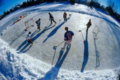 Boys playing hockey on outdoor rink, Winnipeg, Manitoba, Canada.