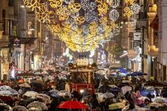 A vintage tram runs along Istiklal Street, decorated with New Year lighting, in central Istanbul